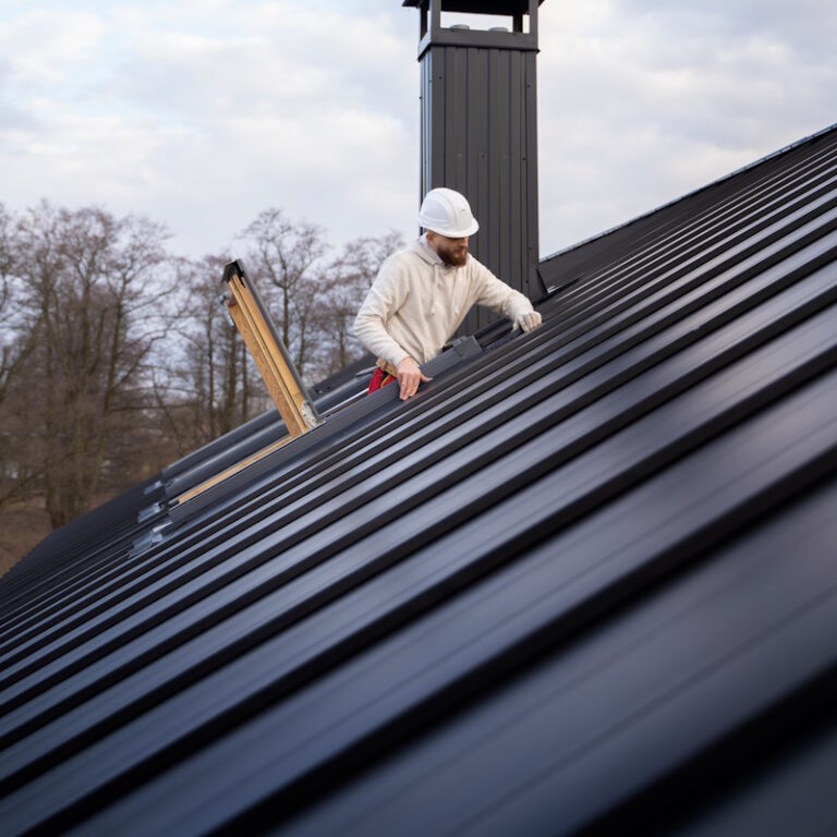 Ouvrier installant une fenêtre sur toit métallique