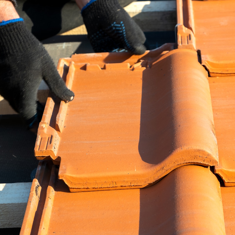 Pose de tuiles en terre cuite sur toit